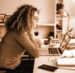 A woman sitting at her desk with a laptop.