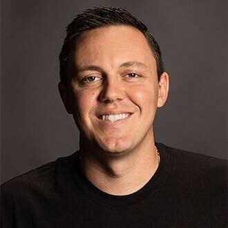 A man with short hair is smiling for the camera.