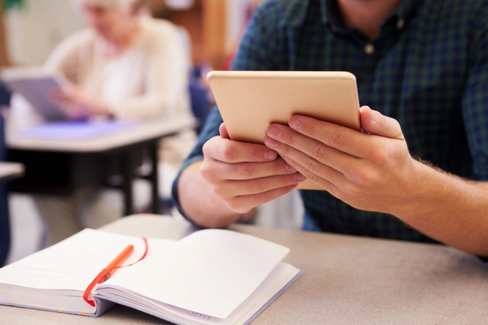 A person is holding an ipad in their hand.