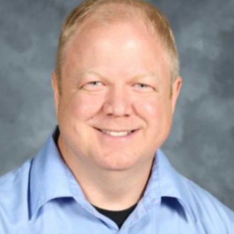 A man with a goatee and blue shirt.