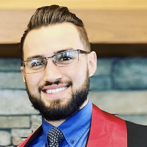 A man with glasses and a red vest